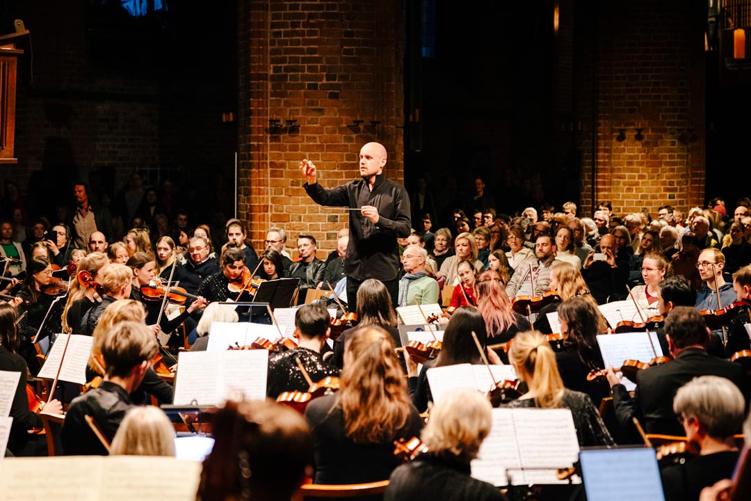 Orchster in einer Kirche, im Zentrum der Dirigent