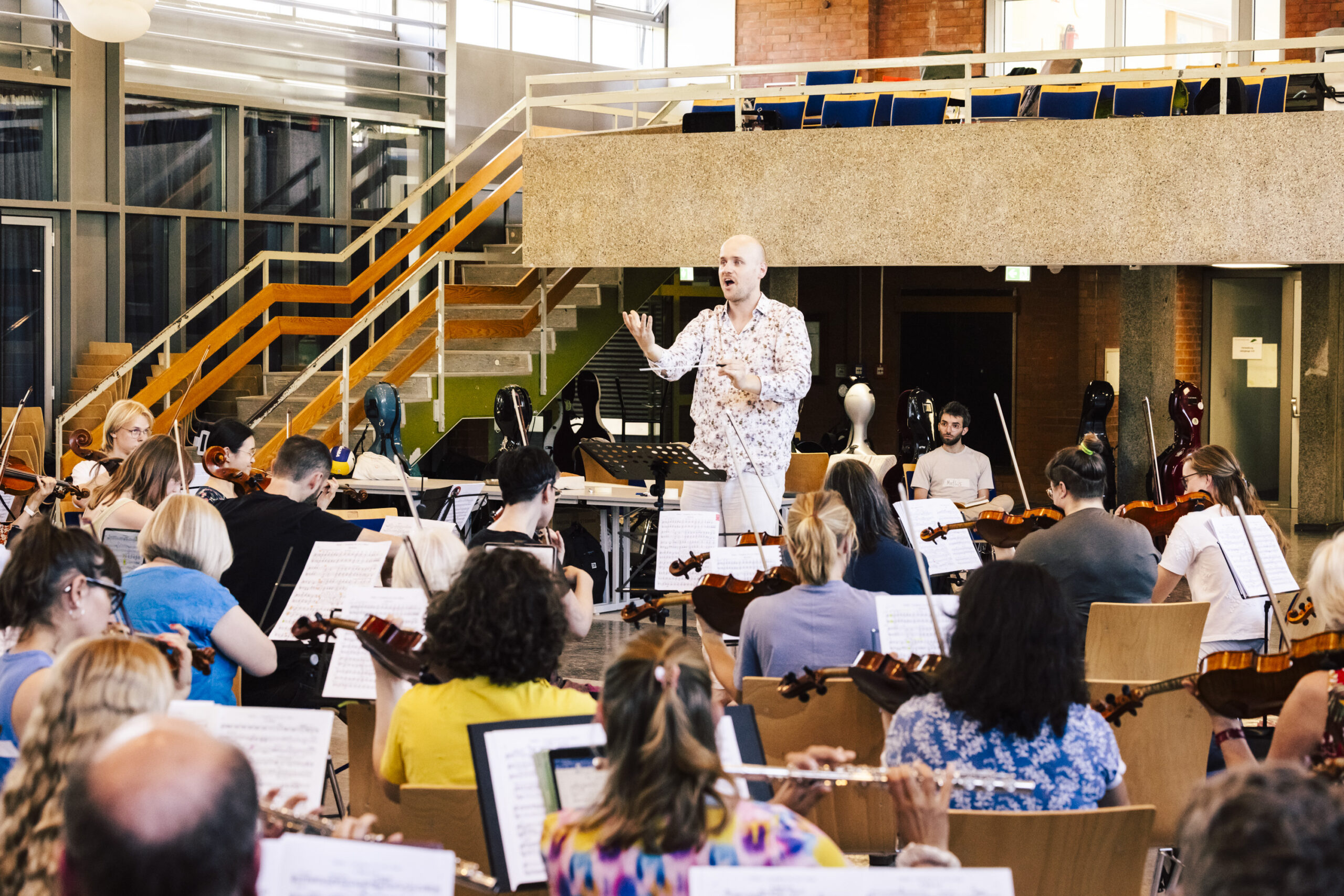 Orchester mit Dirigent in einer Schulaula